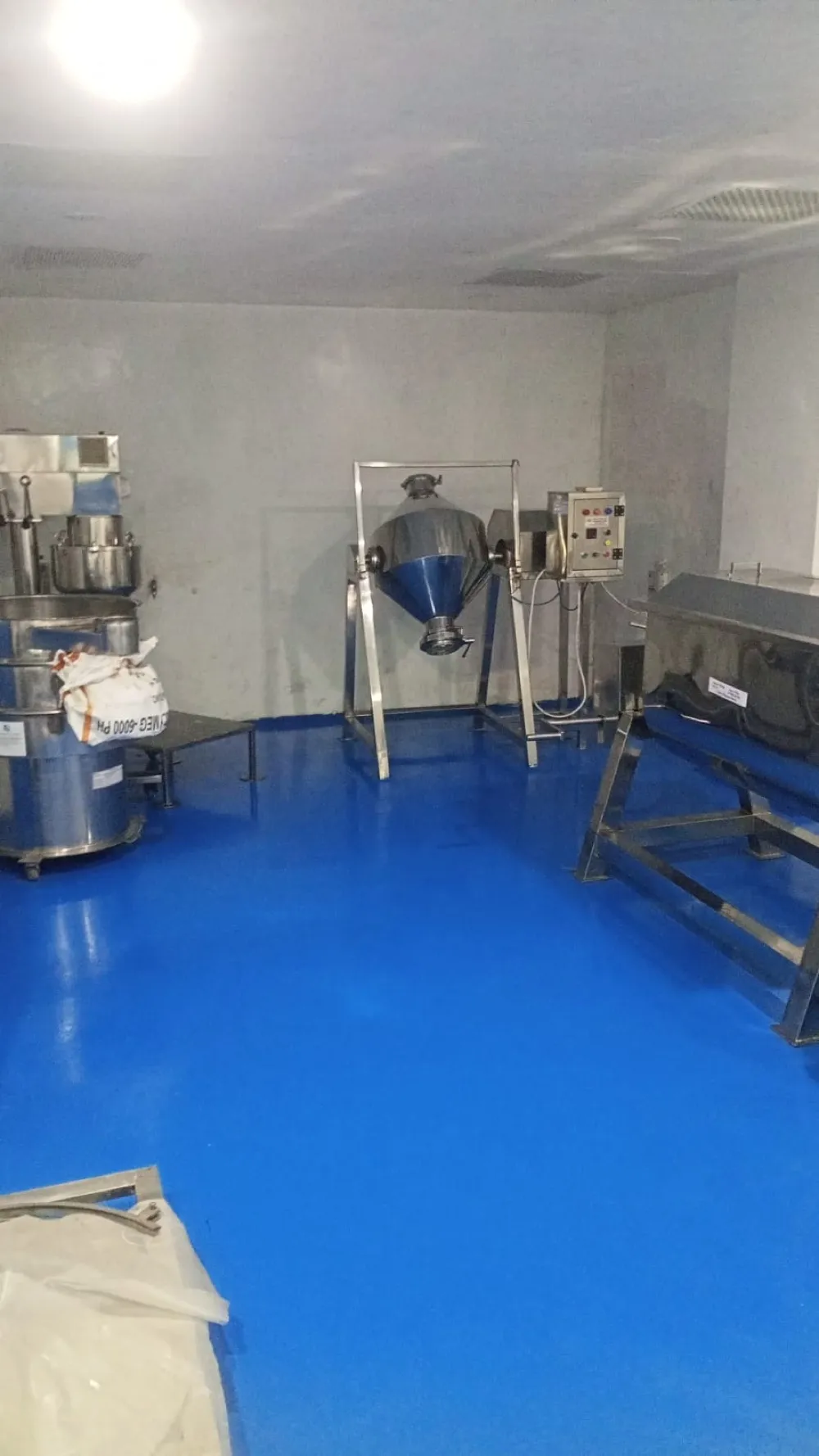 Production area with a cone blender and sifter on an epoxy floor