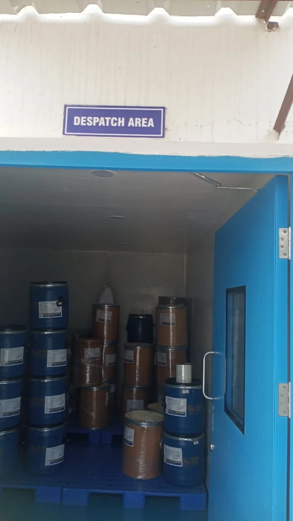Despatch area with Rglax Pharma branded drums stacked on pallets