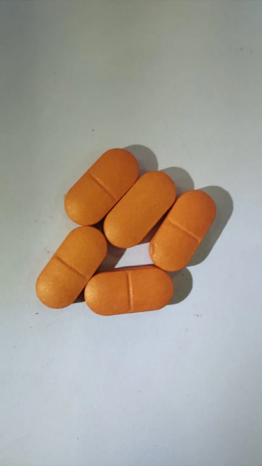 Orange aqueous film coated caplets with a break line