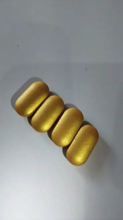 Metallic gold non-aqueous film coated caplets